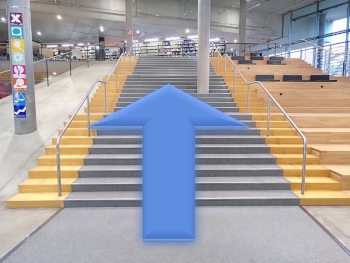 Die große Treppe der UB. Ein Pfeil zeigt Richtujng 1. OG. 